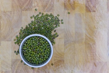 Mung beans piled up in a white ceramic cup.