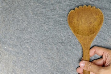 hand holding a wooden ladle