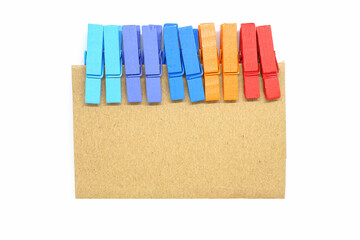 Brown notepad with colorful clip on white background.