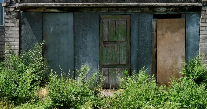 Three different doors in the exterior of an obsolete abandoned brick building