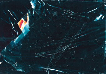 Cracked glass background. Fractured ice texture. Teal blue scratched surface with dust orange glow.