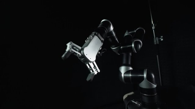 Futuristic robot arm moves randomly in space, system failure, mad robot on black background, dance of the robot manipulator.