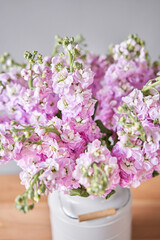 Bouquet of Beautiful lilac mattiola. Spring flowers in vase on wooden table. Flowers delivery.