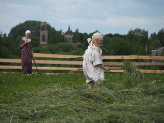 Life of a child in the village. Children's work in the hay field
