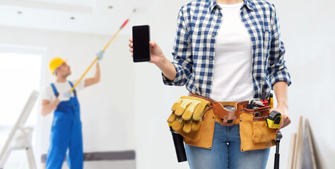repair, construction and building concept - woman or builder with smartphone and working tools on...