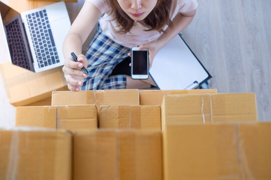 Women are checking products based on customer orders online through the application. Women selling  online work at home as small business owners. Online selling and small business concept