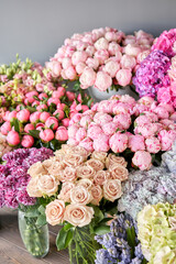 Many different colors on the stand or wooden table in the flower shop. Showcase. Background of mix of flowers. Beautiful flowers for catalog or online store. Floral shop and delivery concept. Top view