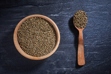 hemp seeds and a wooden spoon on a dark table. Healthy food concept.