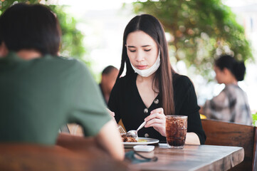 New normal Asian women face mask eating in restaurant
