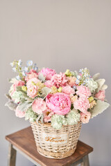 Beautiful flower composition a bouquet in a wicker basket. Floristry concept. Spring colors