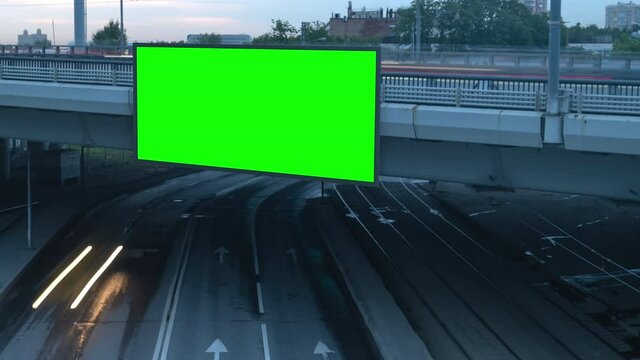 Large billboard with a green screen for advertising on a bridge with traffic and trams, timelapse of traffic at sunset, Moscow, Russia