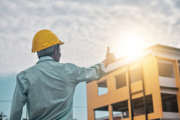 Businessman yellow hard hat standing at building estate construction site project professional engineer