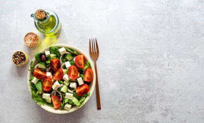 Greek salad of fresh cucumber, tomato, lettuce, red onion, feta cheese, and kalamata olives. Healthy food, top view