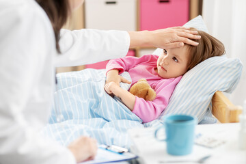 Obraz na płótnie Canvas healthcare, medicine and people concept - close up of doctor measuring temperature of little sick girl lying in bed at home