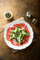 Homemade beef carpaccio with arugula and cheese
