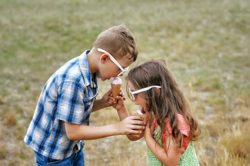 Portrait of cheerful children with ice cream in nature . Beautiful children on a summer day