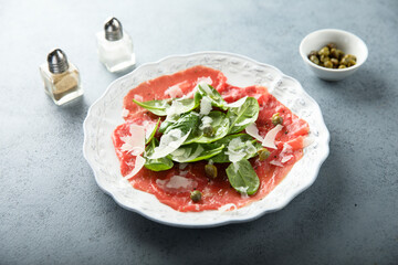 Homemade beef carpaccio with arugula and cheese