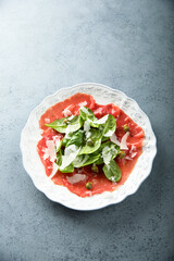 Homemade beef carpaccio with arugula and cheese