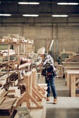 Female carpenter working at the factory