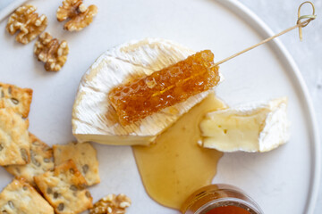Camembert cheese, white wine honey and snack on white marble background