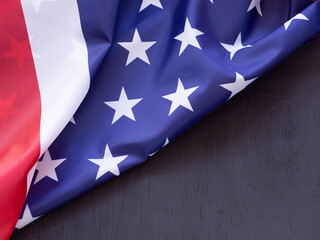 Close-up, the beautiful fabric American flag on black wooden background. Independence day concept...