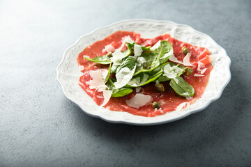 Homemade beef carpaccio with arugula and cheese