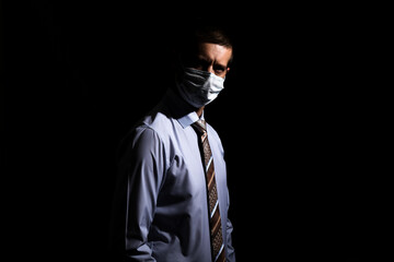 business successful man in a medical mask, slave and tie, portrait. on black