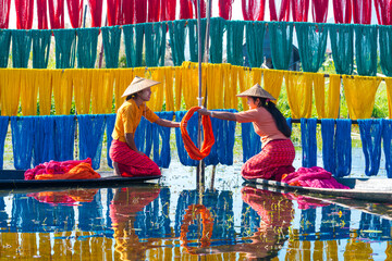 Obraz na płótnie Canvas Intha people working with handcrafted colorful lotus fabrics in inle lake is life style of intha village. They used sun nature make dry cloths. 