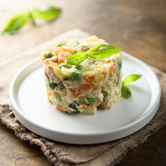 Traditional homemade Olivier salad on a white plate