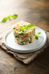Traditional homemade Olivier salad on a white plate
