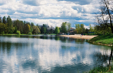Fototapeta premium Film shot of the summer landscape with lake and small beach on a cloudy day. 