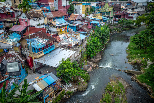 Colorful homes tightly packed together along a river in Indonesia.