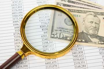 Financial documents - reports, dollars and magnifying glass. Financial concept
