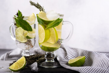 Mojito cocktail with lime and mint in highball glass on a grey stone background Copy space
