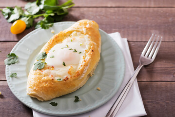 Khachapuri, open pie with chees and egg. Adjarian Khachapuri is a traditional Georgian dis. Street food.