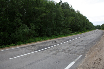 sudden harsh difference and contrast between a good and bad weathered damaged road at Vladimir Okrug border.