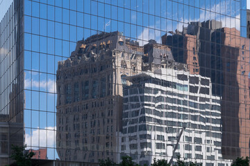 Buildings and sky reflected in the glass windows of a skyscraper in New York, USA