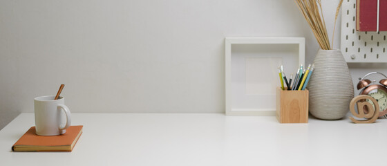 Obraz na płótnie Canvas Modern home office desk with copy space, mug above notebook, stationery and decorations
