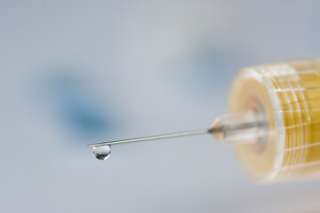 Syringe with a thin needle and some pills.