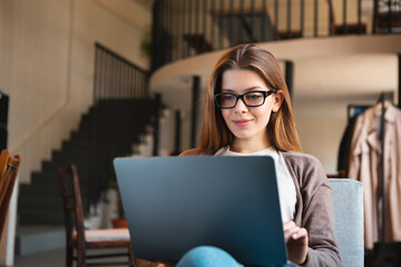 Young businesswoman sitting in cafe with laptop and planning new trip