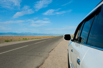 Fototapeta na wymiar Car in mountains landscape. Road in desert