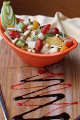 Fresh Fruit Salad in Red Bowl on Dark Background