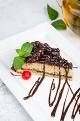 A piece of cake with bird cherry on a white plate