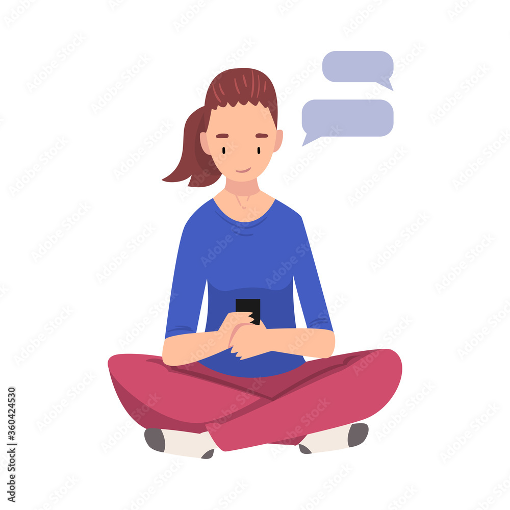 Wall mural girl hatting via internet using smartphone, female student sitting on the floor with crossed legs an