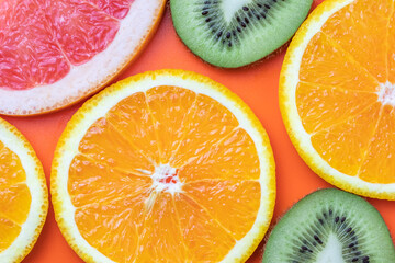 Naklejka na ściany i meble Citrus fruits, tropical background. Slices of grapefruit, kiwi, orange. Summer colorful wallpaper.