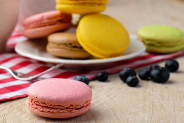 French macaroon cookies of bright colors served in white ceramic plate