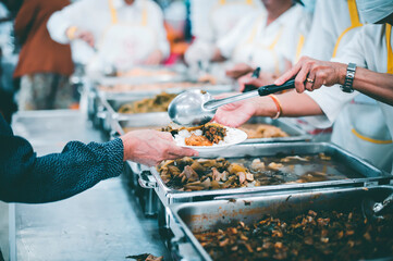 Obraz premium The hands of beggars receive donated food : The concept of food shortages