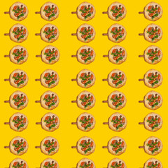 Vegetarian homemade pizza with vegetables and herbs on a yellow background.