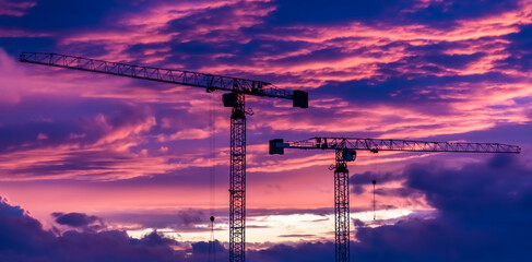 banner Construction site with cranes on purple sunset.