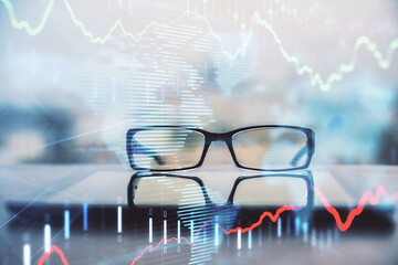 Financial graph hologram with glasses on the table background. Concept of business. Double exposure.